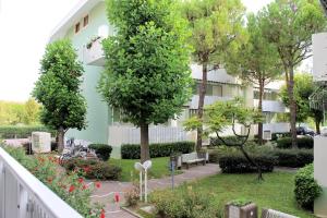 グラードにあるAppartamenti Rosannaの木々と花の庭園のある建物