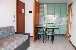 a small kitchen with a table and chairs and a couch at Appartamenti Rosanna in Grado