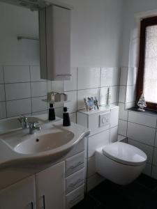 Baño blanco con lavabo y aseo en Ferienwohnung Jessica, en Schafstedt