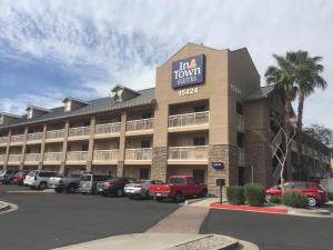 a hotel with cars parked in a parking lot at InTown Suites Extended Stay Phoenix AZ - West in Phoenix