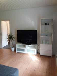 a living room with a flat screen tv on a white entertainment center at Ferienwohnung Jessica in Schafstedt