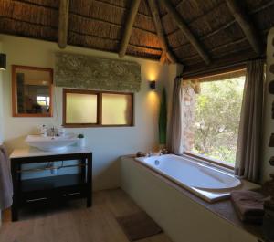 uma casa de banho com uma banheira grande e um lavatório em Woodbury Lodge – Amakhala Game Reserve em Amakhala Game Reserve