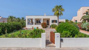 uma casa branca com uma cerca à frente. em Casa Antonio Sea View em Cala Santanyi