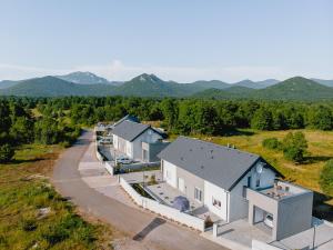 an aerial view of a house with mountains in the background at Degenia Velebitica in Lovinac