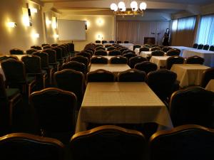 una sala conferenze con tavoli, sedie e schermo di Hotel Electra a Orestiada