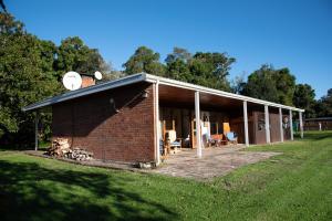 a brick building with a large patio in a field at Natures Way Farmhouse in The Crags