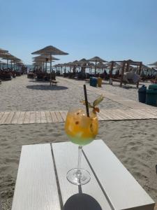 a drink sitting on a table on the beach at Apartament Raldar Mamaia Nord in Mamaia Nord