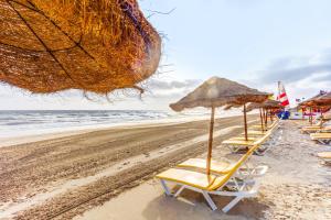 a row of beach chairs and umbrellas on a beach at TUI MAGIC LIFE Penelope Beach - Families & Couples in Midoun