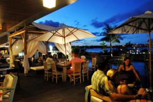 a group of people sitting around a table with umbrellas at Flat Romântico à Beira Lago M 401 in Brasilia