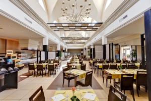 a restaurant with tables and chairs and a chandelier at TUI MAGIC LIFE Penelope Beach - Families & Couples in Midoun