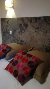 a bed with red and pink pillows on it at MARGARIDOU in Blesle