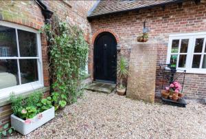 a brick house with a door and some plants at Hanger Down House Bed and Breakfast in Arundel