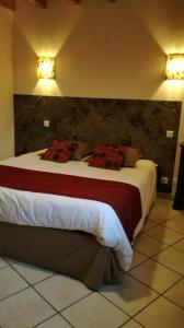 a bedroom with a large bed with red pillows at MARGARIDOU in Blesle