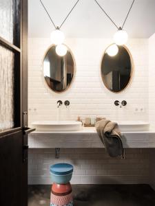 a bathroom with two mirrors and a sink at Loft im Stadl in Innervillgraten