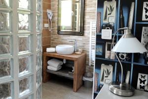 un bagno con lavandino e specchio di Logis Hôtel L'Ayguelade a Bielle