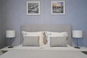 
a bed with a white comforter and pillows on it at My Charm Lisbon Suites in Lisbon
