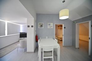 
a kitchen with a table, chairs and a refrigerator at My Charm Lisbon Suites in Lisbon
