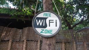 a free wifi sign hanging on a tree at Eco-Home Siem Reap Homestay in Siem Reap