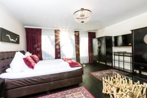 a living room with a bed and a television at Landidyll-Hotel Nudelbacher in Feldkirchen in Kärnten