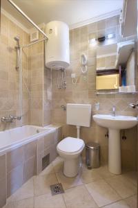 a bathroom with a toilet and a sink and a tub at Apartment Kovacevic Old Town in Budva