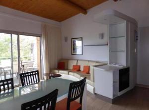 a living room with a table and chairs and a couch at Porto-Vecchio Baie Santa Giulia appartement une chambre 4-5 personnes in Porto-Vecchio