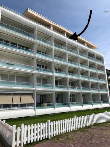 una recinzione bianca di fronte a un edificio di Alte Teestube Appartement 3 Penthouse a Norderney