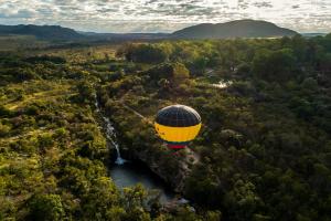 a hot air balloon flying over a waterfall at Hotel Recanto Verde in Teresina de Goias