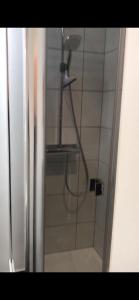 een douche met een douchekop in de badkamer bij Alte Teestube Appartement 3 Penthouse in Norderney