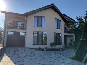 a large house with a garage and a driveway at Eden Blue in Costinesti