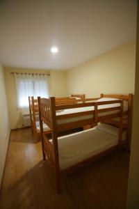 two bunk beds in a room with a window at Albergue La Encina in Hospital de Órbigo