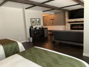 sala de estar con sofá y chimenea en Cedar Stables Inn & Suites, en Sandusky