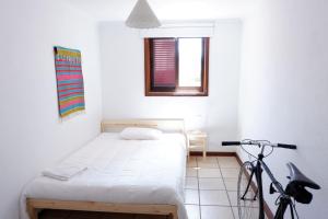 a bedroom with a bed and a bike in it at Kame House in Vila Nova de Gaia