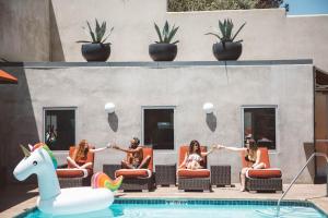 a group of women sitting on chairs by a pool at Hotel Angeleno in Los Angeles