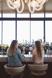two women sitting at a bar talking at Hotel Angeleno in Los Angeles