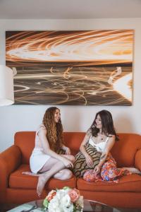 two women are sitting on a couch at Hotel Angeleno in Los Angeles