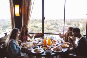a group of people sitting around a table eating food at Hotel Angeleno in Los Angeles