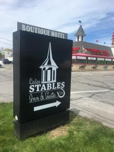 a sign for a hotel in front of a street at Cedar Stables Inn & Suites in Sandusky