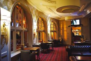 a restaurant with tables and chairs in a room at Argyll Hotel in Dunoon