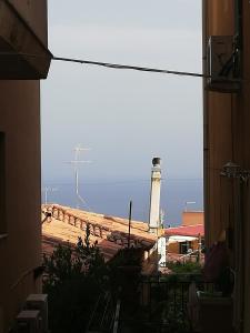 a view of a lighthouse from a window of a building at Sicitaly taormina in Taormina +42 photos