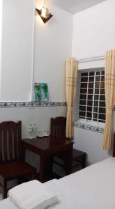 フーコックにあるPhu Quoc Beach Guesthouseのテーブルと椅子、窓が備わる客室です。