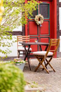 a table and a chair in front of a red building at Schwesterherz im Schlafrock in Merxleben in Bad Langensalza