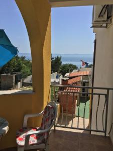 a balcony with a chair and a view of the ocean at Apartments Medusa in Makarska