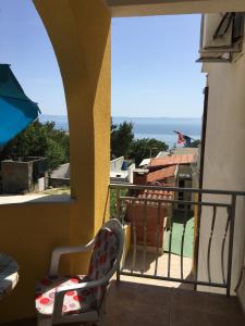 a balcony with a chair and a view of the ocean at Apartments Medusa in Makarska