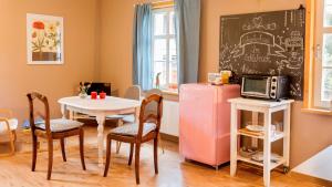 a small dining room with a table and a refrigerator at Schwesterherz im Schlafrock in Merxleben in Bad Langensalza