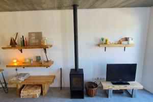 salon z piecem opalanym drewnem i telewizorem w obiekcie Casa Bombordo w mieście Carrapateira
