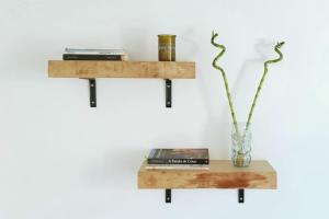 a shelf with a vase and books on a wall at Casa Bombordo in Carrapateira
