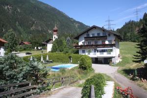 a house with a pool in front of a mountain at Casa da Honna in Matrei in Osttirol