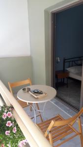 einen weißen Tisch und Stühle in einem Zimmer mit Balkon in der Unterkunft Sivota apartments Parthenia in Syvota