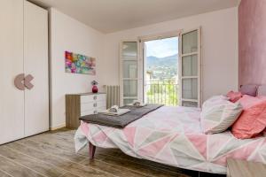 ein Schlafzimmer mit einem großen Bett und einem Fenster in der Unterkunft Corte Fasanella - Apartment Lillà in Toscolano-Maderno