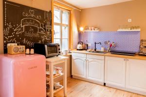 a kitchen with a refrigerator and a chalkboard on the wall at Schwesterherz im Schlafrock in Merxleben in Bad Langensalza